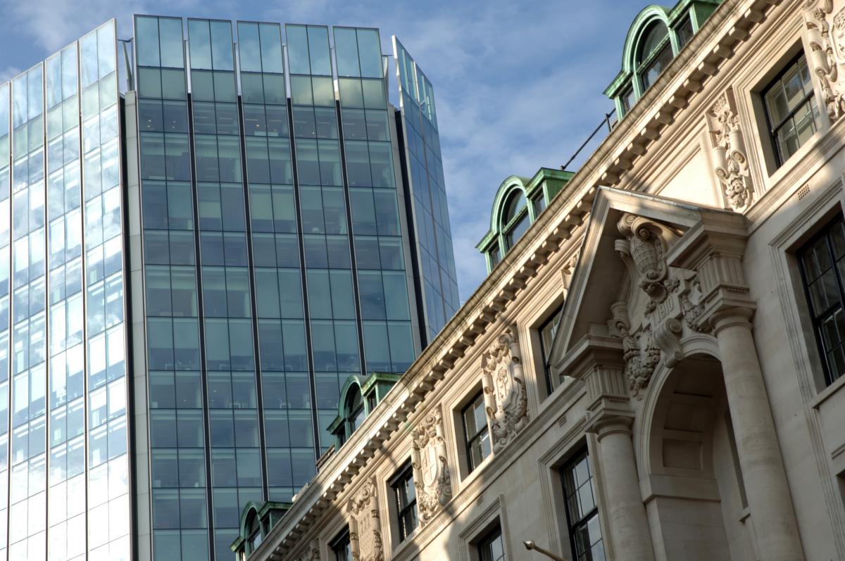 a view of a modern skyscaper and an older building